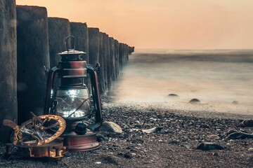 Lantern and compass rest on the pebbled shore of Wustrow, Germany