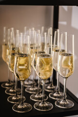 Champagne glasses in restaurant. Champagne flutes in holiday. Glasses are filled with champaign. Celebration of the Happy New Year 2024, Christmas holidays, birthday party, wedding and baptism.