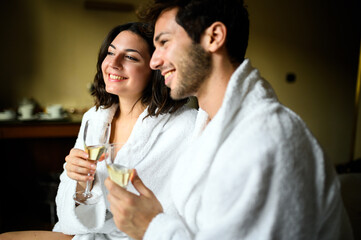 Happy couple enjoying champagne in robes