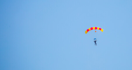 Skydiving. Flying parachutists against the background of the blue sky and mountains. Extreme sport and entertainment.