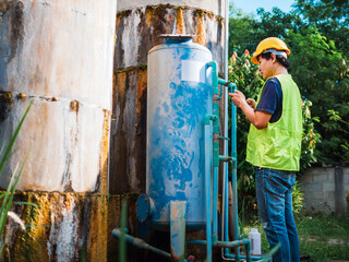 Asian man engineer controlling the quality of water places operating industrial water purification...