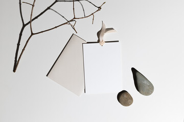 Flatlay gift certificate with an envelope of branches and stones