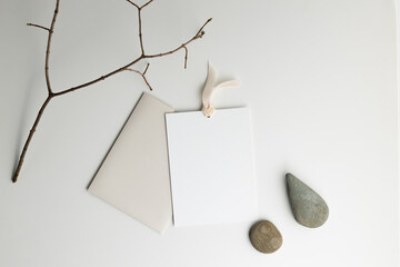 Flatlay gift certificate envelope with branches and stones with soft lighting