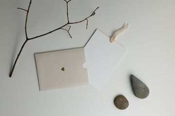 Composition with a dry branch with stones and a gift envelope