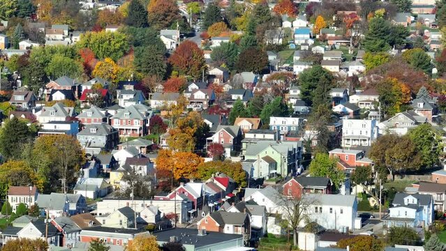 Residential suburb with colorful autumn trees. Aerial shot of neighborhood in American town.