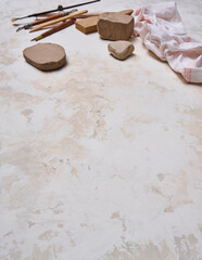 Making ceramic, women's hands and tools on the decorative table style background, up view.