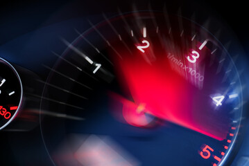 Motion blur of a car instrument panel dashboard odometer with red illuminated display.Car speedometer. High speed car speedometer and motion blur at night. - obrazy, fototapety, plakaty