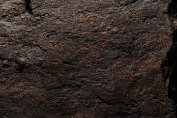 Brown stone texture, dark abstract background. Natural mineral rock close up details, empty backdrop with copy space for design
