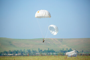 Skydiving. Flying parachutists against the background of the blue sky and mountains. Extreme sport...