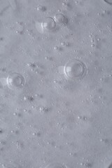 Clear cosmetic serum on light background, macro view