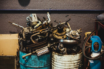 Car engine parts in a container for recycling in a car workshop. Environmental concept.