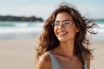 Naklejka premium Young smiling hispanic woman wearing eyeglasses looking side on the beach