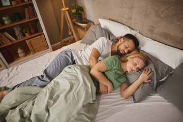 Couple sleeping embraced in bed
