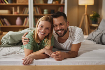 Portrait of smiling couple lying on bed