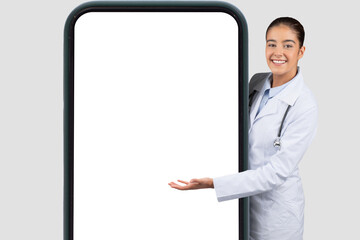 Confident happy european young doctor in white coat point hand on big phone