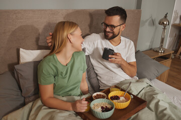 Couple in love having breakfast in bed