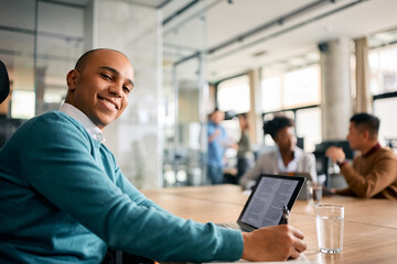 Happy black entrepreneur working in office and looking at camera.