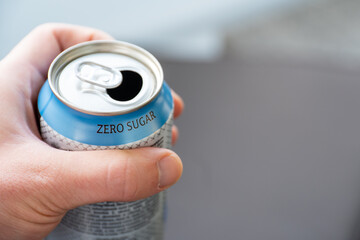 hand holding a zero sugar soda can.