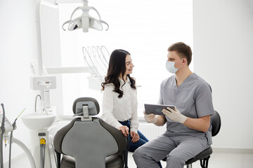 Male dentist with digital tablet. Modern treatment in professional dental clinic.