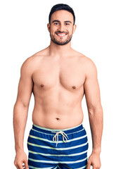 Young handsome man wearing swimwear with a happy and cool smile on face. lucky person.