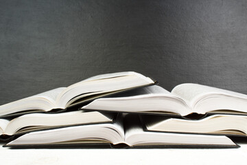 Open book on wooden deck table and black board background. Back to School. Education concept with copy space for your ad text.