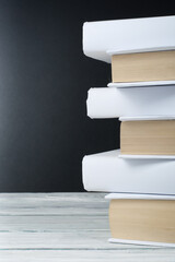Open books on wooden table, black board background. Back to school. Education business concept.