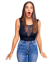 Young hispanic woman wearing casual clothes afraid and shocked with surprise and amazed expression, fear and excited face.