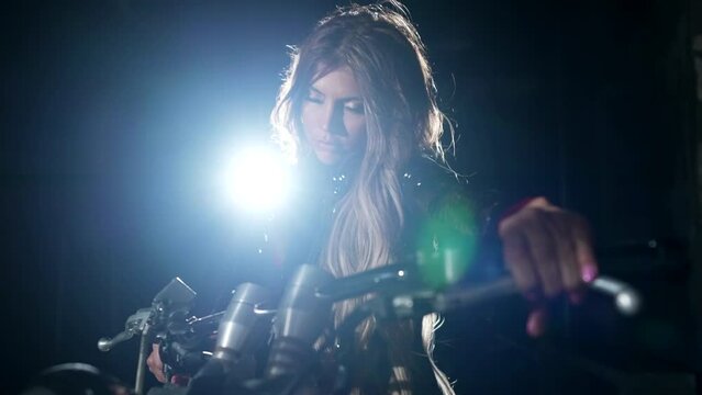 sexy woman on motorbike in darkness, silhouette of female figure against bright soffit