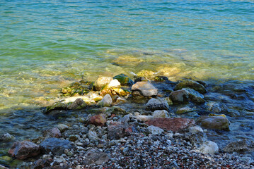 Sunlight on Rocky Beach and Clear Waters of Shallow Lake