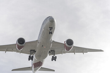 A large cargo jet with the landing gear deployed about to land at the airport