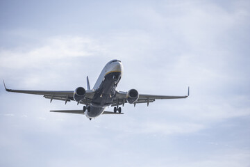 A multi-hued passenger plane approaching a runway