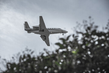 A small private passenger jet approaching land to land