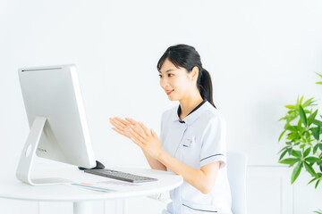 パソコンでビデオ通話する医療従事者の女性