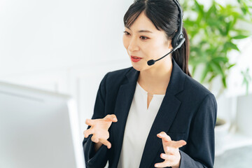 電話応対する女性オペレーター　コールセンター　カスタマーサポート