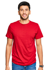 Young handsome man wearing casual red tshirt with a happy and cool smile on face. lucky person.