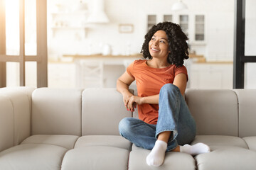 Portrait Of Beautiful Smiling Black Woman Relaxing On Comfortable Couch At Home
