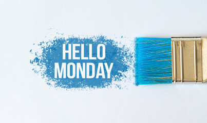 Hello Monday text on blue paint with brush on white background