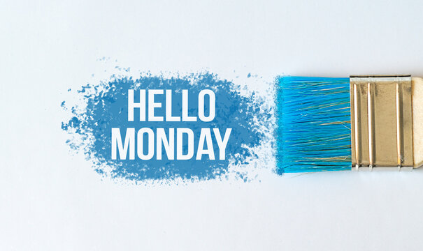 Hello Monday text on blue paint with brush on white background