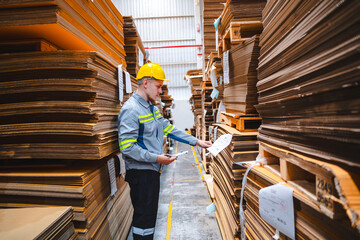 Naklejka na ściany i meble Professional worker team in safety uniform, supervisor inspector in packaging stock order at cardboard factory warehouse, piles of stacking paper manufacture, recycling industrial production