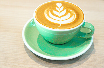 Artful Brew: Hot Coffee Latte Art in a Green Mug