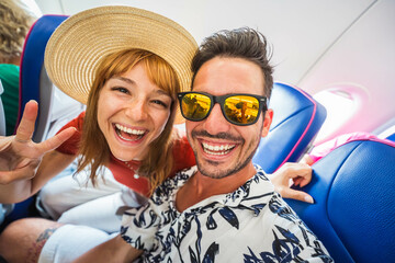 Happy tourist taking selfie inside airplane - Cheerful couple on summer vacation - Passengers boarding on plane - Holidays and transportation concept	
 - obrazy, fototapety, plakaty