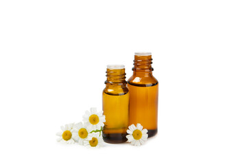 Glass bottle with chamomile essential oil isolated on white background. Chamomile flowers, close up. Aromatherapy, spa and herbal medicine ingredients. Beauty concept. Natural cosmetics