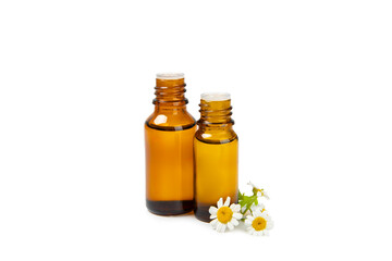 Glass bottle with chamomile essential oil isolated on white background. Chamomile flowers, close up. Aromatherapy, spa and herbal medicine ingredients. Beauty concept. Natural cosmetics