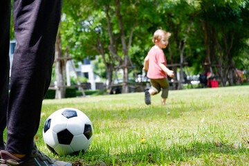 Obraz na płótnie Canvas A boy runs and kicks football in the grass.