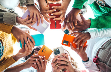 Group of young people using smart mobile phone device outside - Trendy technology concept with guys and girls playing video games app on smartphone - Bright colorful filter - obrazy, fototapety, plakaty
