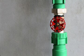 Water pressure gauge with valve in pipe on concrete wall background.