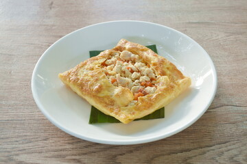 fried mashed pork with tomato and onion stuffed in Thai egg omelets on plate