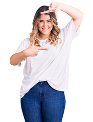 Fototapeta premium Young caucasian woman wearing casual clothes smiling making frame with hands and fingers with happy face. creativity and photography concept.