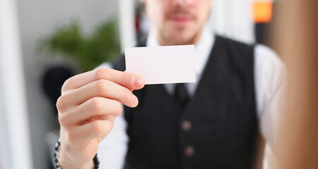 Male hand in suit give blank calling card to female visitor closeup. White collar partners company...