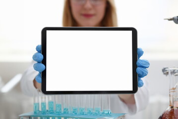 A female doctor in a chemical laboratory holds a tablet in his hand with display, you can insert a...